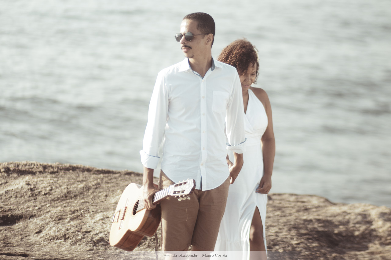 casal passeando com violão na praia