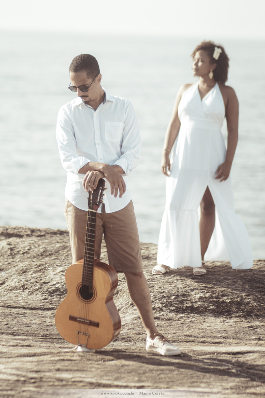 casal fazendo pose com violão na praia